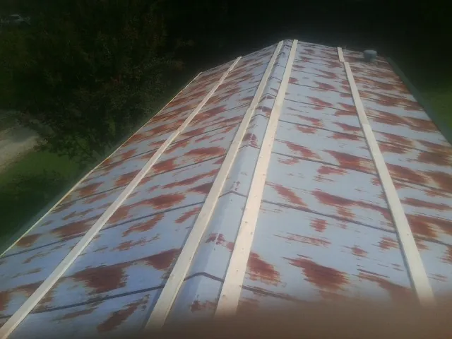 Rusted metal roof panels with new wood purlins before replacement — Storm Damage Roof Repair in Honeoye by Roofing Brothers